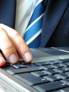 man in suit typing on computer